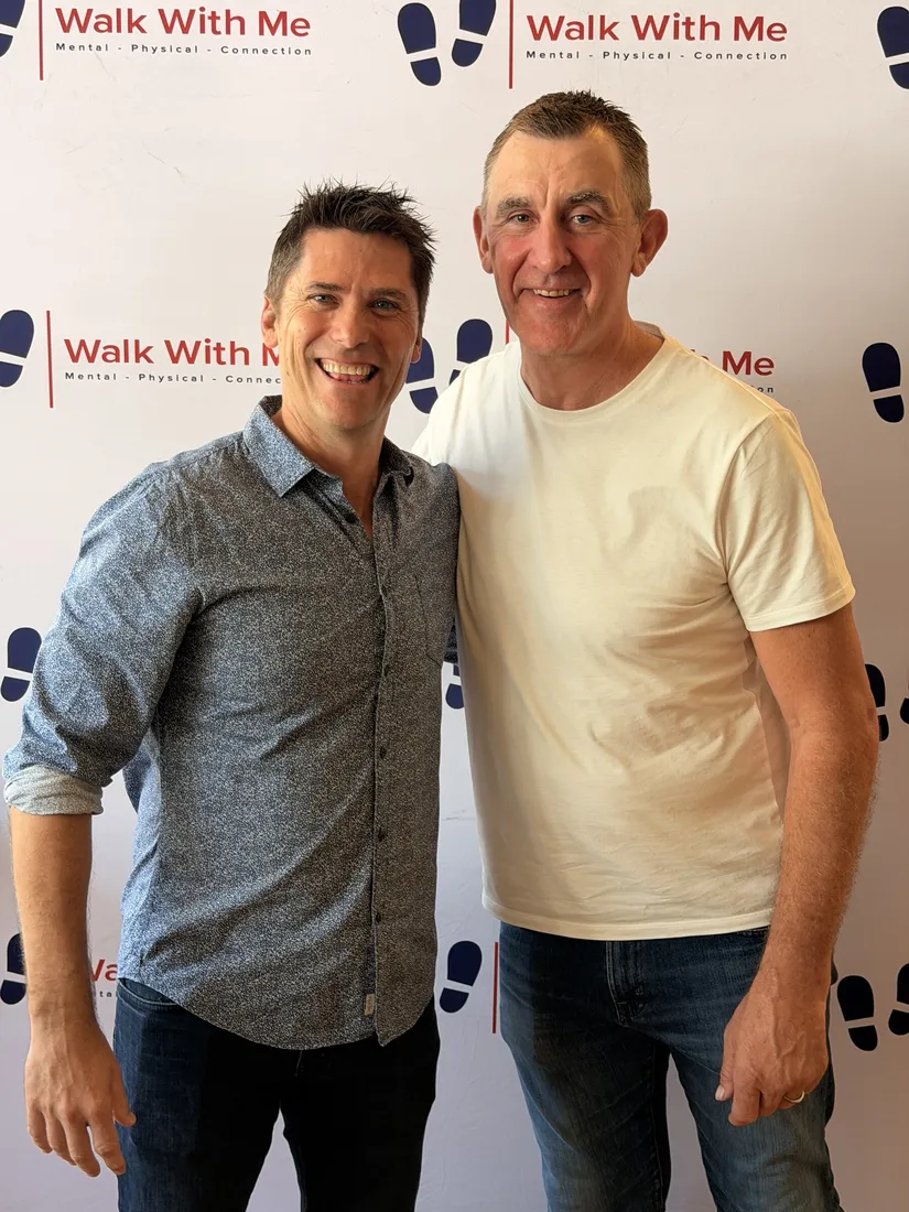 Two guests together in front of the Walk With Me backdrop