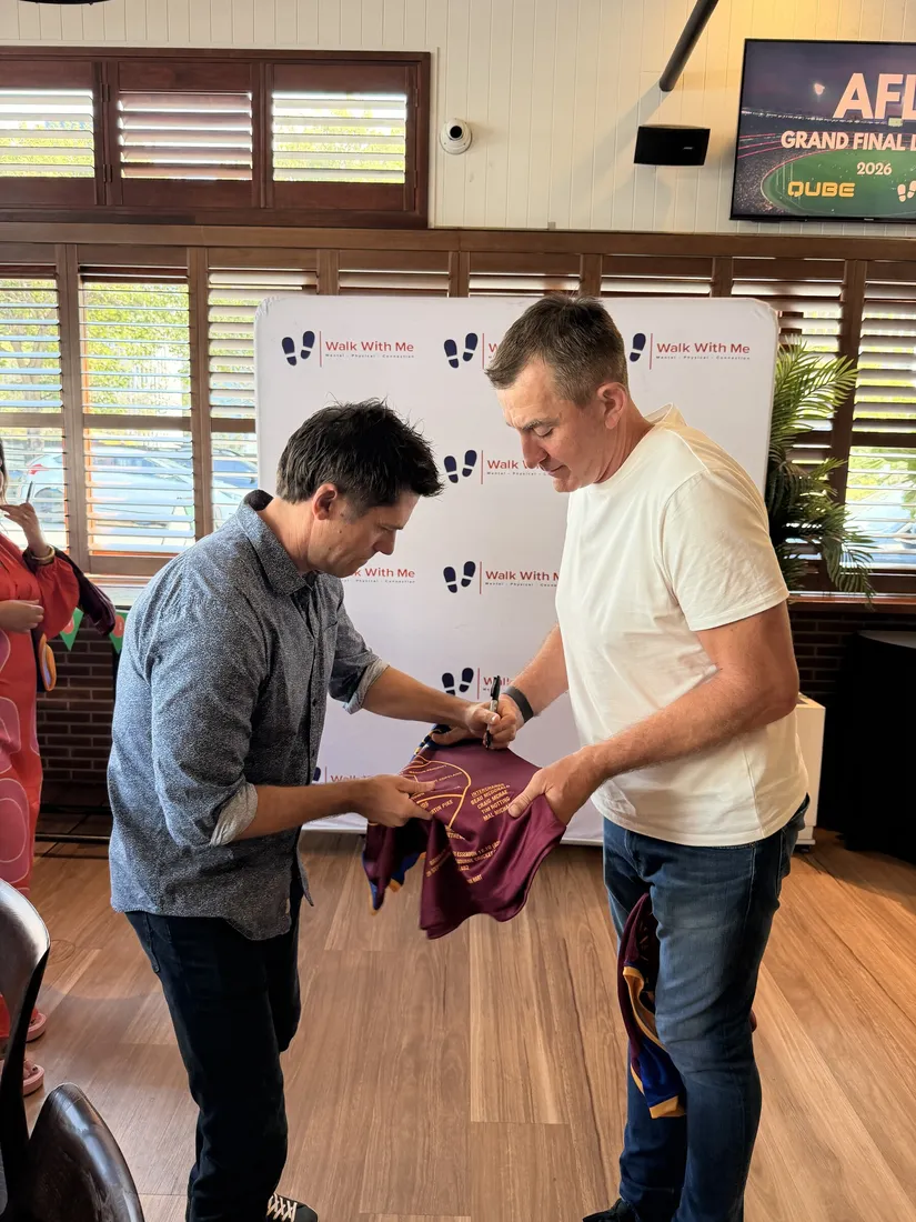 Guests presenting a football jersey at the Brisbane event