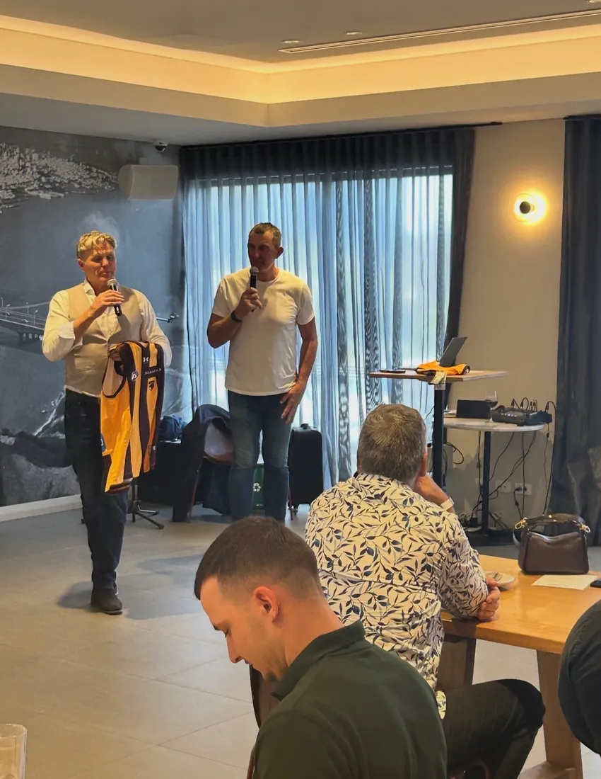 Speakers presenting a football jersey at the Perth lunch